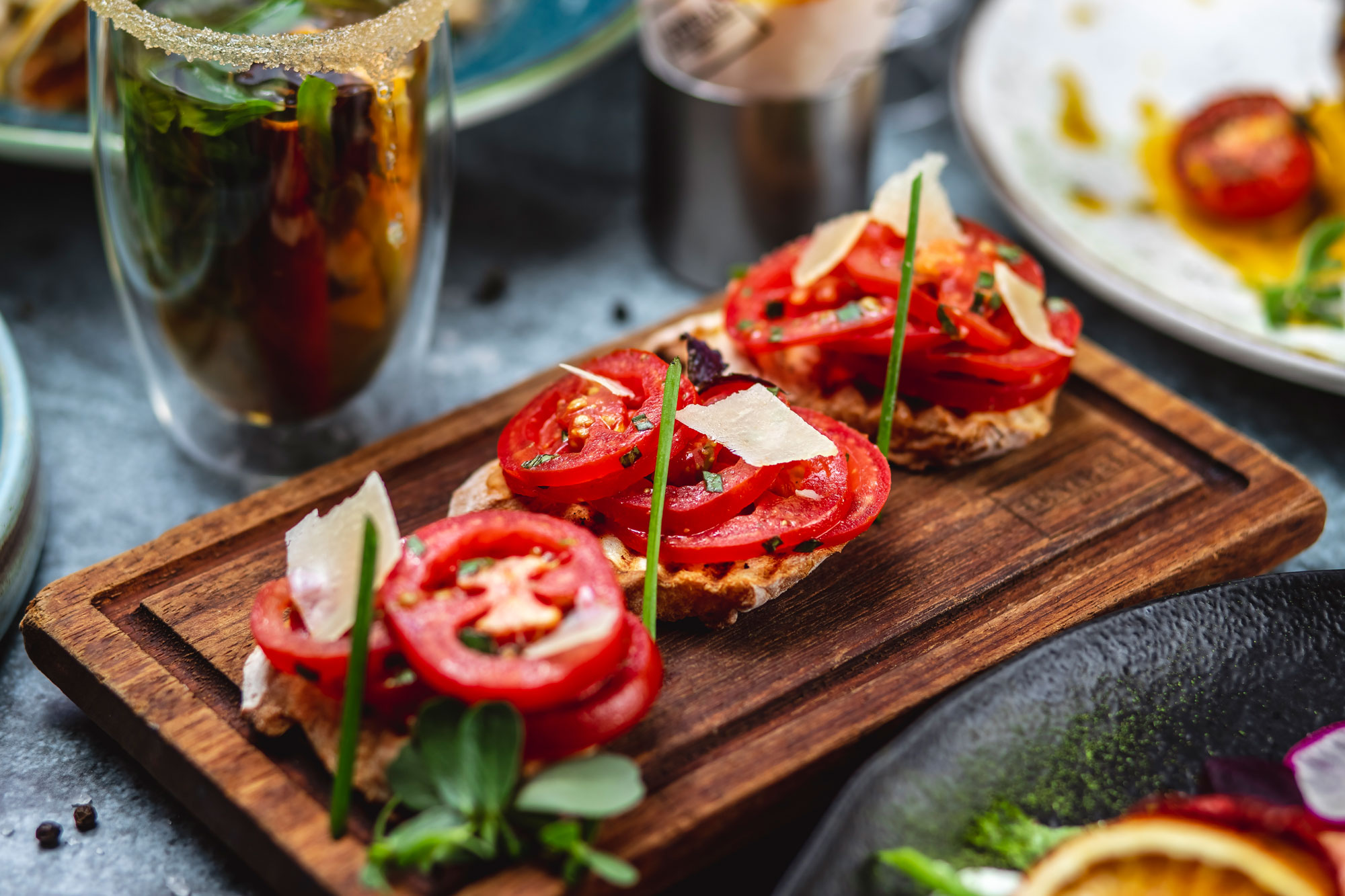 side-view-bruschetta-with-tomatoes-basil-spring-onion-parmesan-board-klein
